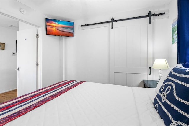 12458 1st St W, Treasure Island, FL 33706 - bedroom with a barn door and wood finished floors