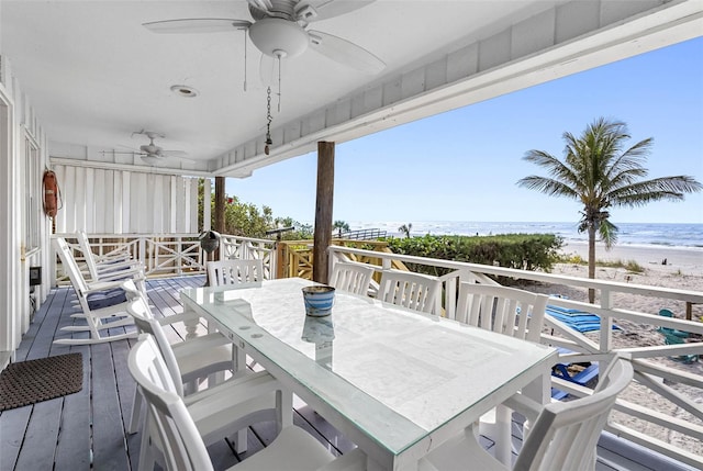 12458 1st St W, Treasure Island, FL 33706 - wooden deck with a ceiling fan, outdoor dining area, and view of water and beach