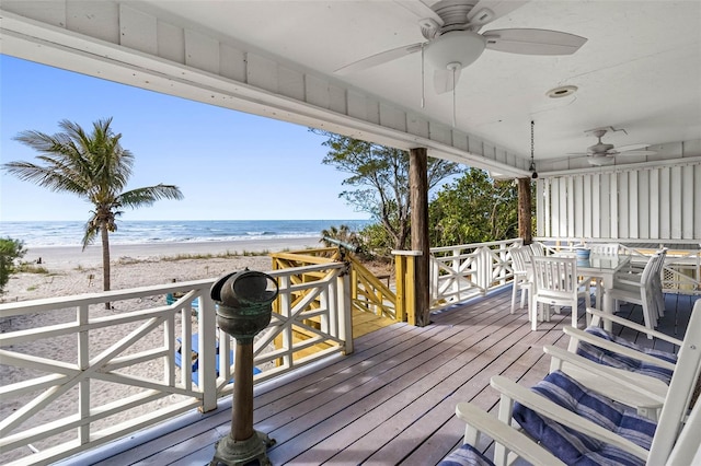 12458 1st St W, Treasure Island, FL 33706 - wooden deck featuring ceiling fan, view of water and beach, and outdoor dining area