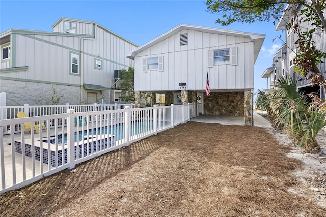 12458 1st St W, Treasure Island, FL 33706 - back of house with a carport, board and batten siding, and stone siding