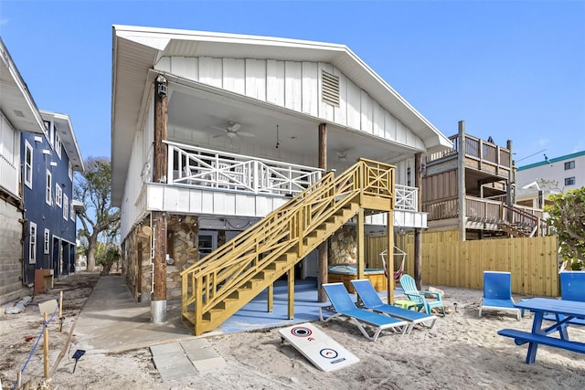 12458 1st St W, Treasure Island, FL 33706 - back of property featuring ceiling fan, stairway, stone siding, and board and batten siding