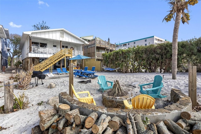 12458 1st St W, Treasure Island, FL 33706 - rear view of property featuring an outdoor fire pit, stairs, and a patio