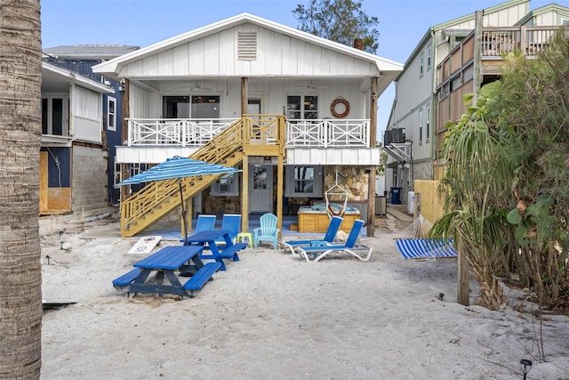 12458 1st St W, Treasure Island, FL 33706 - view of front facade with stone siding, a balcony, and ceiling fan