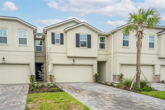 26082 Woven Wicker Bnd, Lutz, FL 33559 - view of property with stucco siding, a garage, and decorative driveway