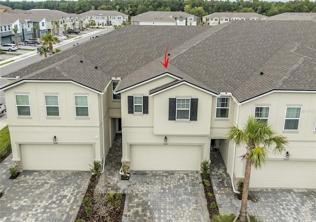 26082 Woven Wicker Bnd, Lutz, FL 33559 - multi unit property featuring an attached garage, stucco siding, a residential view, driveway, and roof with shingles