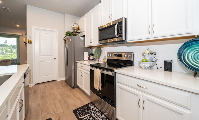 26082 Woven Wicker Bnd, Lutz, FL 33559 - kitchen featuring stainless steel appliances, white cabinetry, backsplash, light countertops, and light wood-style floors
