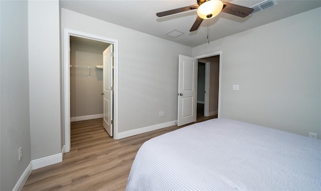 26082 Woven Wicker Bnd, Lutz, FL 33559 - bedroom with light wood-type flooring, a spacious closet, ceiling fan, and a closet