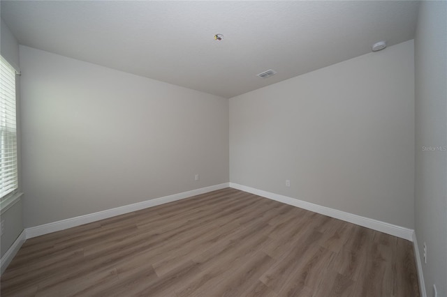 26082 Woven Wicker Bnd, Lutz, FL 33559 - empty room featuring light wood-style floors, healthy amount of natural light, and a smoke detector