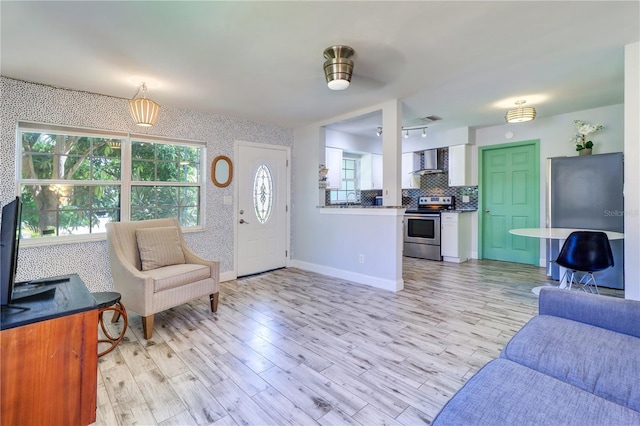 3910 14th Ave N, Saint Petersburg, FL 33713 - living room with wallpapered walls, light wood-style floors, and a ceiling fan