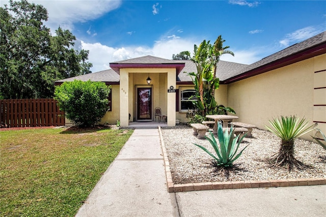 408 River Bed Ct, Wimauma, FL 33598 - doorway to property featuring stucco siding and a shingled roof