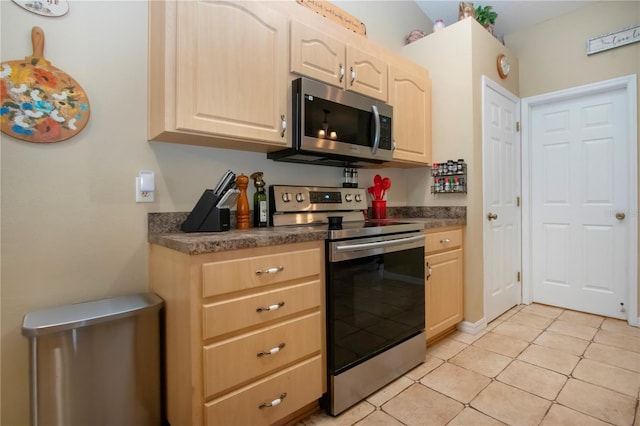 408 River Bed Ct, Wimauma, FL 33598 - kitchen featuring appliances with stainless steel finishes, light brown cabinets, dark countertops, and light tile patterned flooring