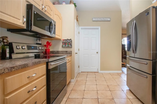 408 River Bed Ct, Wimauma, FL 33598 - kitchen with stainless steel appliances, light brown cabinets, light tile patterned floors, and dark countertops