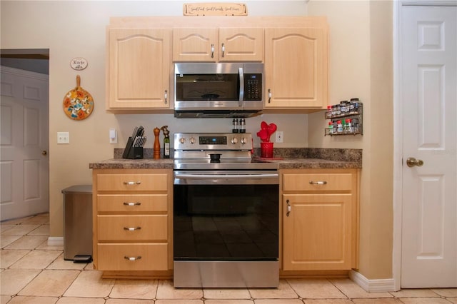 408 River Bed Ct, Wimauma, FL 33598 - kitchen with appliances with stainless steel finishes, light brown cabinetry, dark countertops, and light tile patterned floors