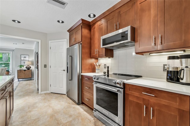 344 Cascade Ln, Palm Harbor, FL 34684 - kitchen featuring appliances with stainless steel finishes, light countertops, backsplash, brown cabinetry, and recessed lighting