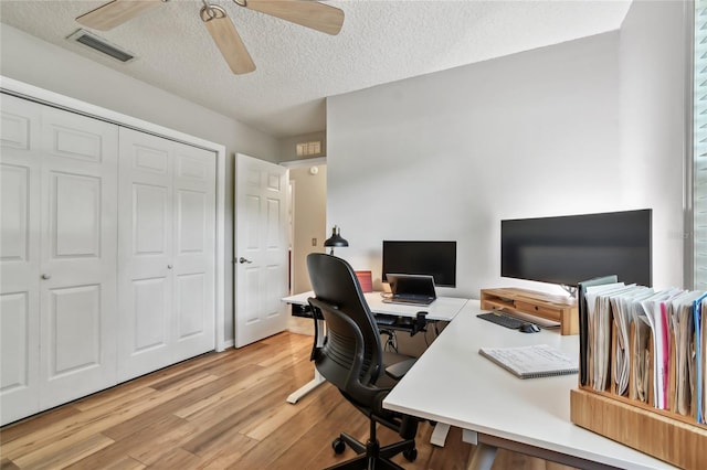 344 Cascade Ln, Palm Harbor, FL 34684 - home office with ceiling fan, light wood-style floors, and a textured ceiling