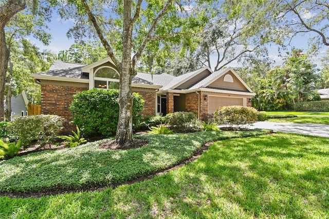 344 Cascade Ln, Palm Harbor, FL 34684 - view of front of house with brick siding, an attached garage, a front yard, concrete driveway, and roof with shingles