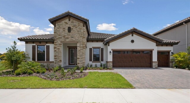 14279 Swiss Bridge Dr, Riverview, FL 33579 - view of front facade featuring a tiled roof, stucco siding, an attached garage, and stone siding