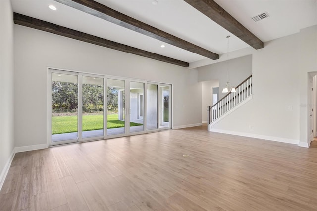14531 Swiss Bridge Dr, Lithia, FL 33547 - unfurnished living room with stairs, light wood-style flooring, beamed ceiling, a chandelier, and recessed lighting