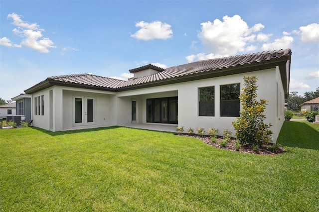 14531 Swiss Bridge Dr, Lithia, FL 33547 - back of property with stucco siding, french doors, a lawn, and a tile roof