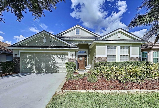 4116 Knollpoint Dr, Wesley Chapel, FL 33544 - view of front of property with stucco siding, stone siding, driveway, and an attached garage