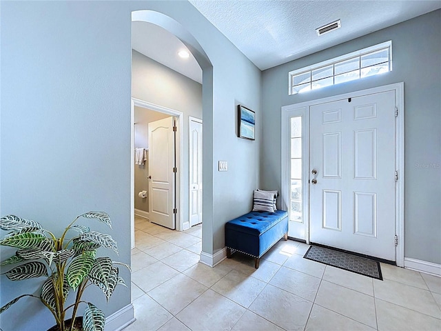 4116 Knollpoint Dr, Wesley Chapel, FL 33544 - entryway with arched walkways, light tile patterned flooring, and a textured ceiling