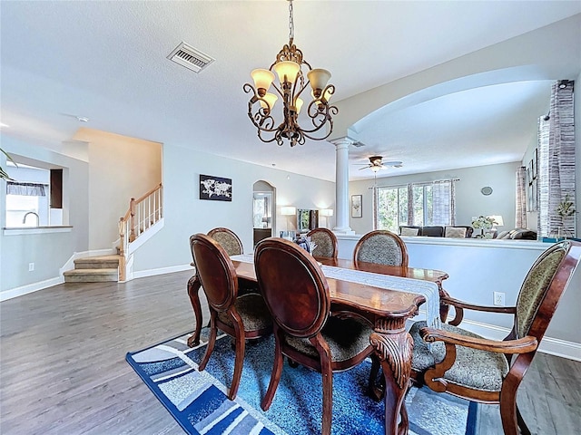 4116 Knollpoint Dr, Wesley Chapel, FL 33544 - dining room with arched walkways, decorative columns, wood finished floors, and stairway