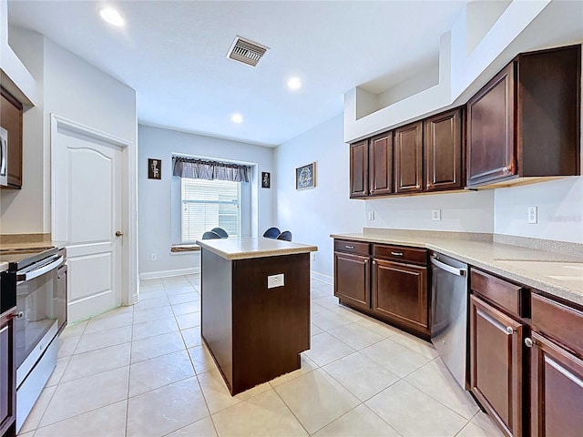 4116 Knollpoint Dr, Wesley Chapel, FL 33544 - kitchen with stainless steel appliances, a kitchen island, light countertops, light tile patterned floors, and recessed lighting
