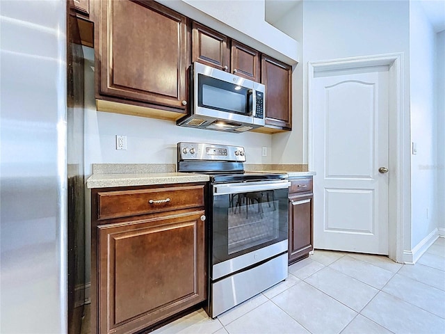 4116 Knollpoint Dr, Wesley Chapel, FL 33544 - kitchen featuring appliances with stainless steel finishes, light countertops, light tile patterned floors, and dark brown cabinetry