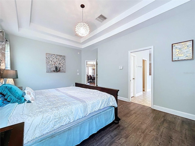 4116 Knollpoint Dr, Wesley Chapel, FL 33544 - bedroom featuring dark wood finished floors, a raised ceiling, and a chandelier