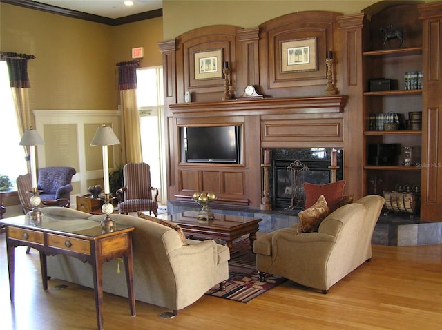 4116 Knollpoint Dr, Wesley Chapel, FL 33544 - living room featuring light wood-style floors, a fireplace, ornamental molding, a wainscoted wall, and a decorative wall