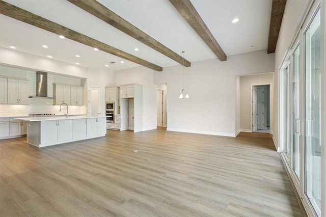 14523 Swiss Bridge Dr, Lithia, FL 33547 - unfurnished living room featuring beam ceiling and light wood-type flooring