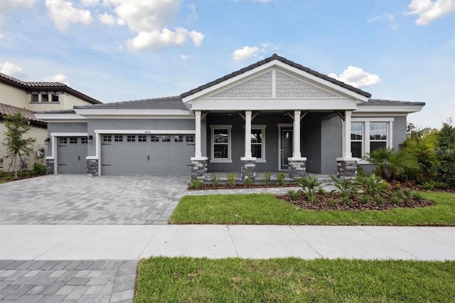 14523 Swiss Bridge Dr, Lithia, FL 33547 - view of front of house with stucco siding, covered porch, decorative driveway, and a garage