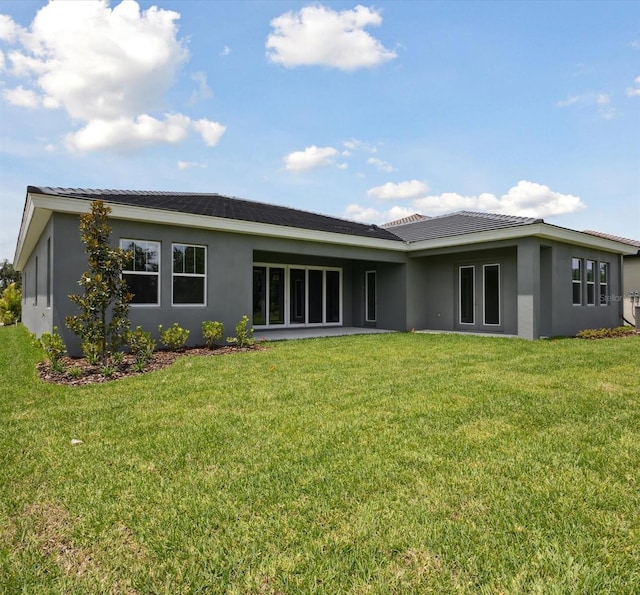 14523 Swiss Bridge Dr, Lithia, FL 33547 - back of house featuring stucco siding and a yard