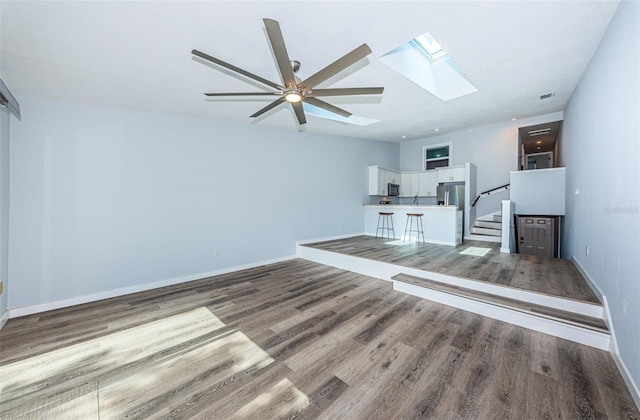 6206 92nd Pl N Unit 3605, Pinellas Park, FL 33782 - unfurnished living room with a skylight, wood finished floors, and a ceiling fan