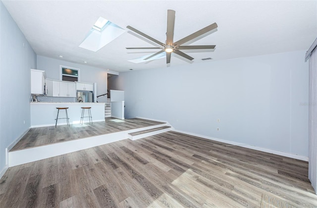 6206 92nd Pl N Unit 3605, Pinellas Park, FL 33782 - unfurnished living room featuring a skylight, light wood-type flooring, and a ceiling fan