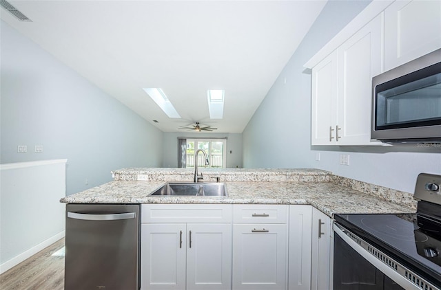 6206 92nd Pl N Unit 3605, Pinellas Park, FL 33782 - kitchen featuring appliances with stainless steel finishes, a skylight, light wood finished floors, and white cabinets