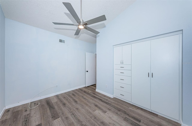 6206 92nd Pl N Unit 3605, Pinellas Park, FL 33782 - unfurnished bedroom with wood finished floors, vaulted ceiling, a closet, a textured ceiling, and a ceiling fan