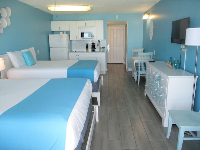9980 Gulf Blvd Unit 408, Treasure Island, FL 33706 - bedroom with freestanding refrigerator and wood finished floors