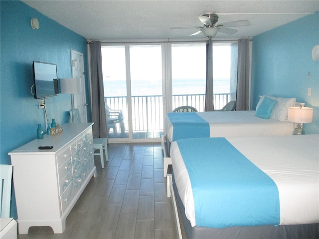 9980 Gulf Blvd Unit 408, Treasure Island, FL 33706 - bedroom featuring access to exterior, a water view, a textured ceiling, and a ceiling fan