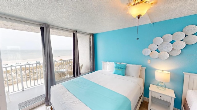 9980 Gulf Blvd Unit 408, Treasure Island, FL 33706 - bedroom featuring a textured ceiling, a water view, and a ceiling fan