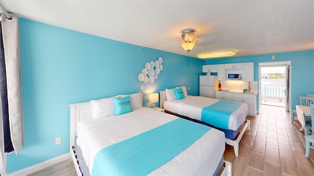 9980 Gulf Blvd Unit 408, Treasure Island, FL 33706 - bedroom featuring freestanding refrigerator, a textured ceiling, ceiling fan, and light wood-style floors