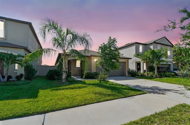 9437 Lemon Drop Loop, Sun City Center, FL 33573 - view of front facade with concrete driveway, an attached garage, a front yard, and stucco siding