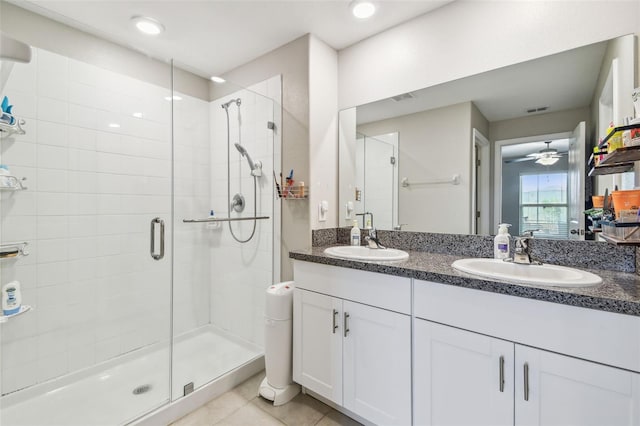 9437 Lemon Drop Loop, Sun City Center, FL 33573 - bathroom with a stall shower, double vanity, tile patterned floors, and ceiling fan