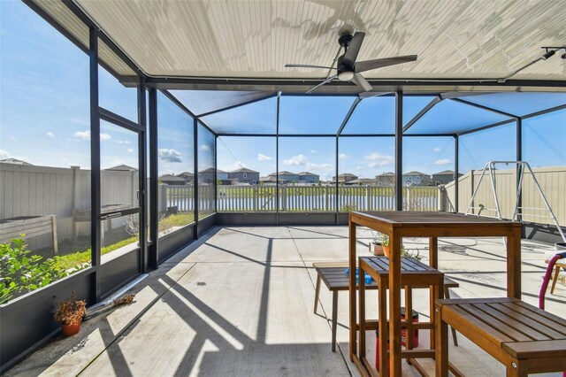 9437 Lemon Drop Loop, Sun City Center, FL 33573 - unfurnished sunroom featuring ceiling fan, a water view, and a residential view