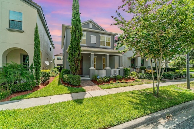 9349 Mira Valle Ln, Winter Garden, FL 34787 - view of front of property featuring stucco siding, a porch, and a front lawn