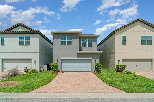 9349 Mira Valle Ln, Winter Garden, FL 34787 - view of front of house featuring an attached garage, stucco siding, decorative driveway, and a front yard