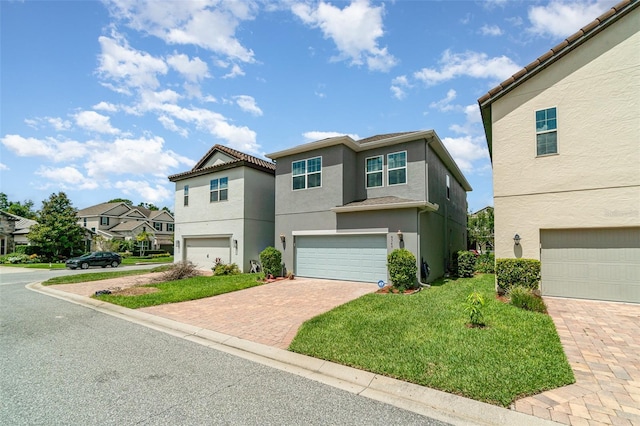 9349 Mira Valle Ln, Winter Garden, FL 34787 - view of front facade featuring decorative driveway, stucco siding, an attached garage, a residential view, and a front lawn