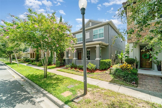 9349 Mira Valle Ln, Winter Garden, FL 34787 - view of front facade with a porch, stucco siding, and a front yard