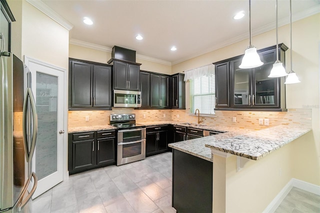 9349 Mira Valle Ln, Winter Garden, FL 34787 - kitchen with stainless steel appliances, a peninsula, dark cabinetry, light stone countertops, and hanging light fixtures