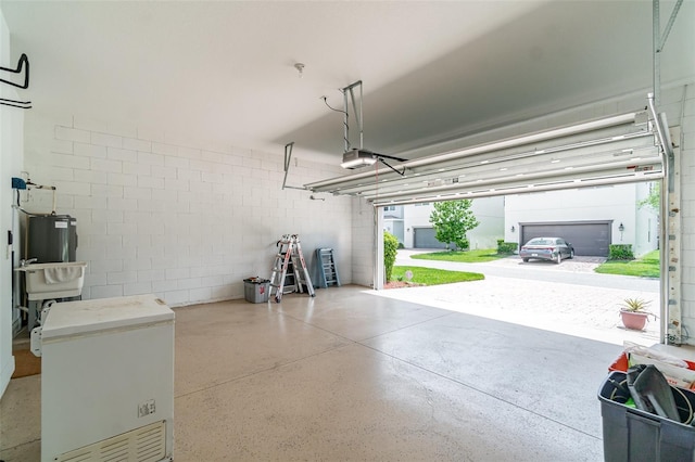 9349 Mira Valle Ln, Winter Garden, FL 34787 - garage featuring fridge, concrete block wall, water heater, and a garage door opener